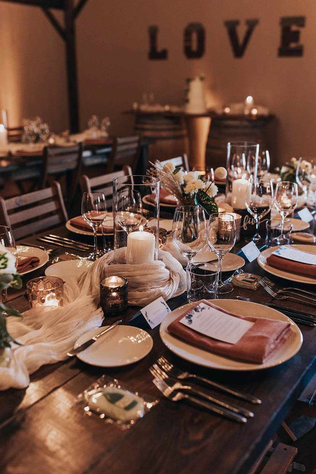 Farm tables set for dinner inside barn