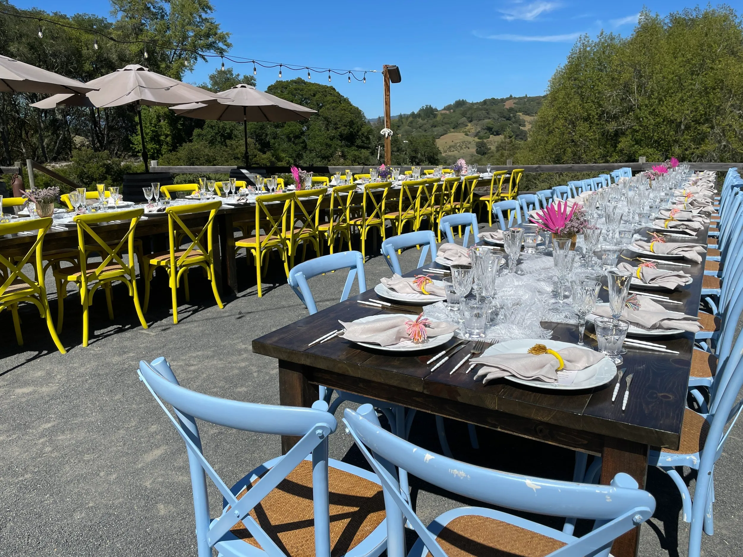 Colorful chairs with farm tables and outdoor wedding dining